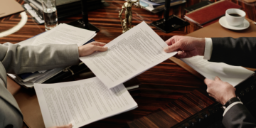 two family law attorneys exchange documents.