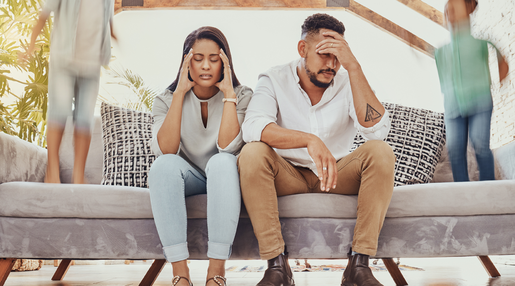 A couple exhibits irritation as the kids are making noise in the background.