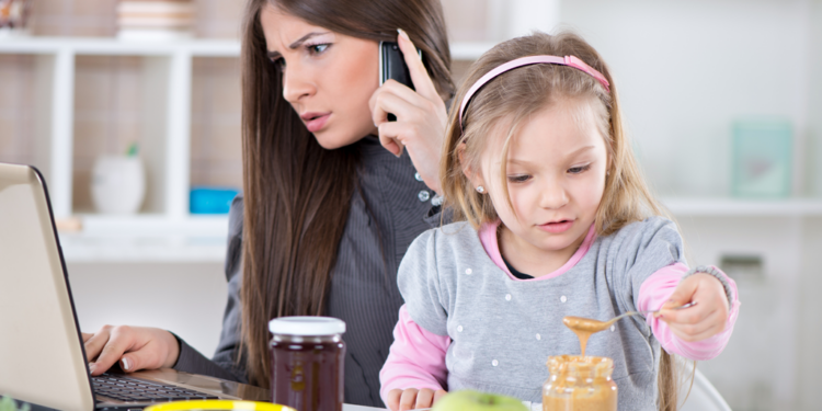 A single mom scrolls financial documents on a laptop.