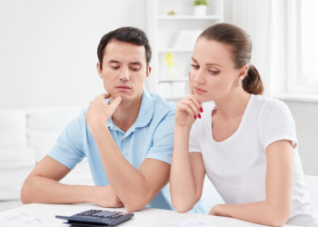 A couple scrutinizes financial documents.