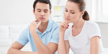 A couple scrutinizes financial documents.