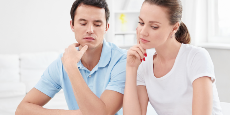A couple scrutinizes financial documents.