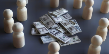 A few wads of money are surrounded by wooden pieces.