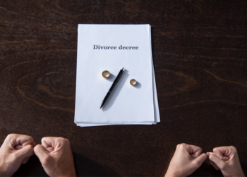 A couple extends hands towards divorce papaers.