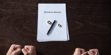 A couple extends hands towards divorce papaers.