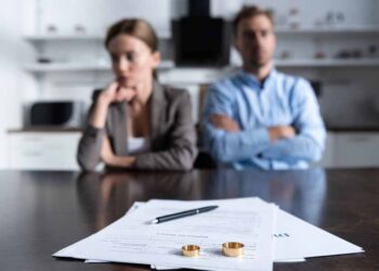 Focus of couple sitting at table with divorce documents