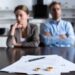 Focus of couple sitting at table with divorce documents