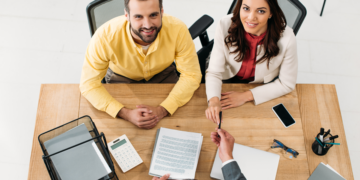 A couple sign documents.