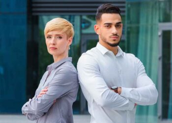 A confident successful couple looks angry while posing for a picture.