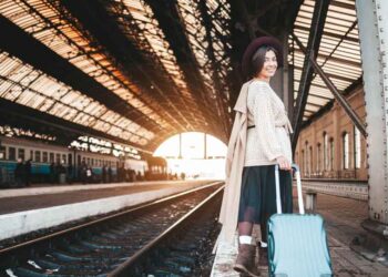 A smiling woman at the railway station.