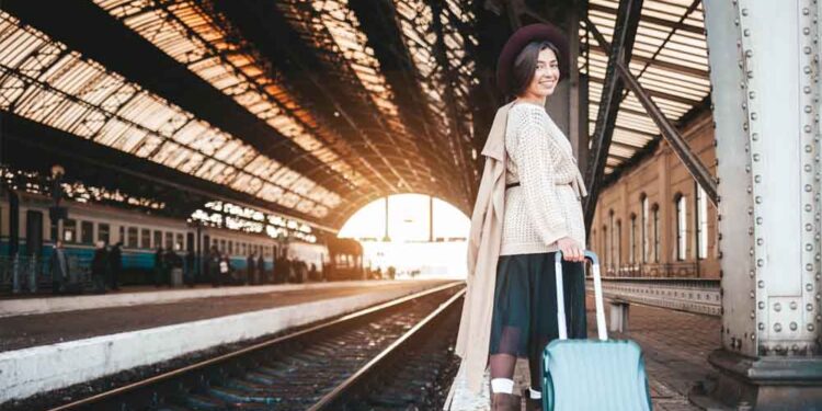 A smiling woman at the railway station.